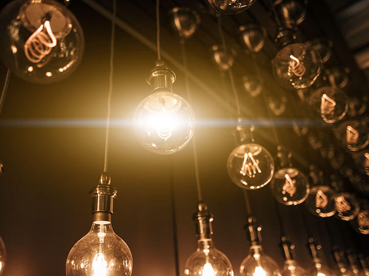 hanging light bulbs in a row with on bulb lit up