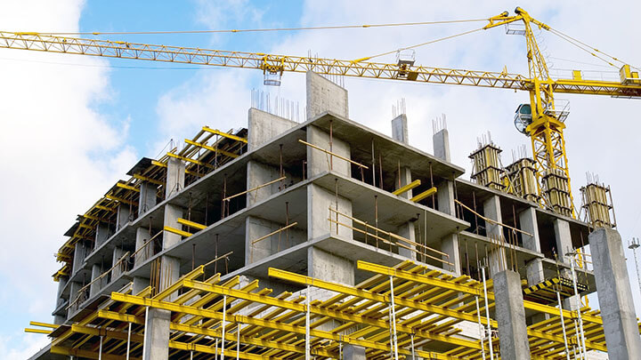 Large office building  under construction with scaffolding and a crane