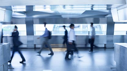 Time lapse image of several business people walking with luggage at an airport